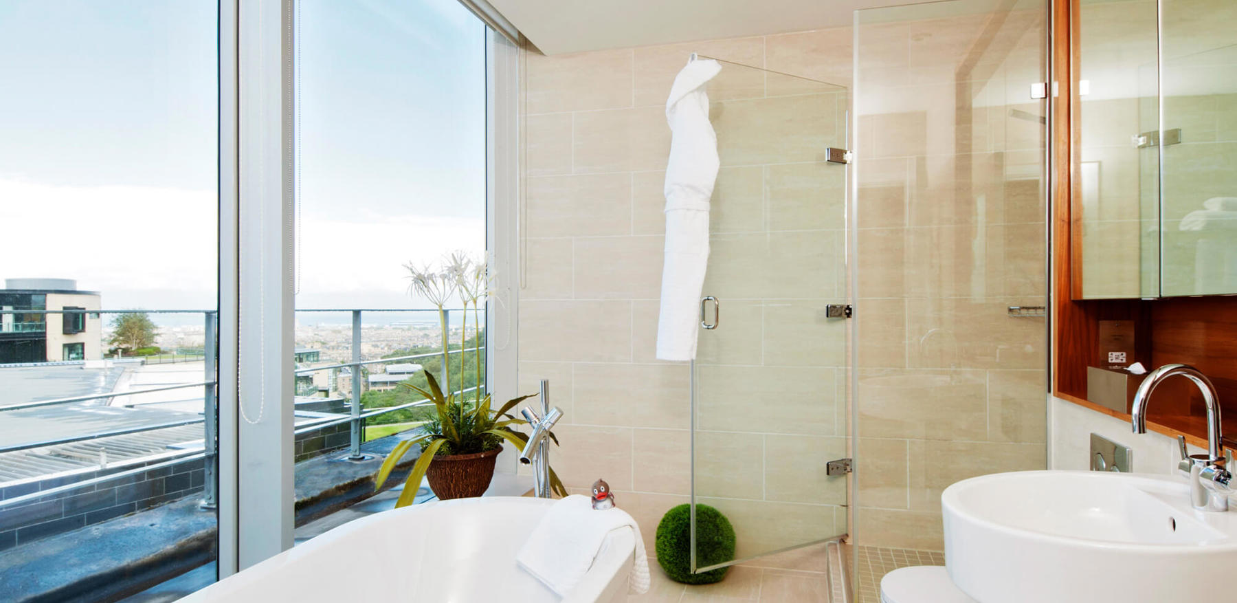 Master Suite bathroom with free standing bathtub and floor-to-ceiling windows at Apex Waterloo Place Hotel