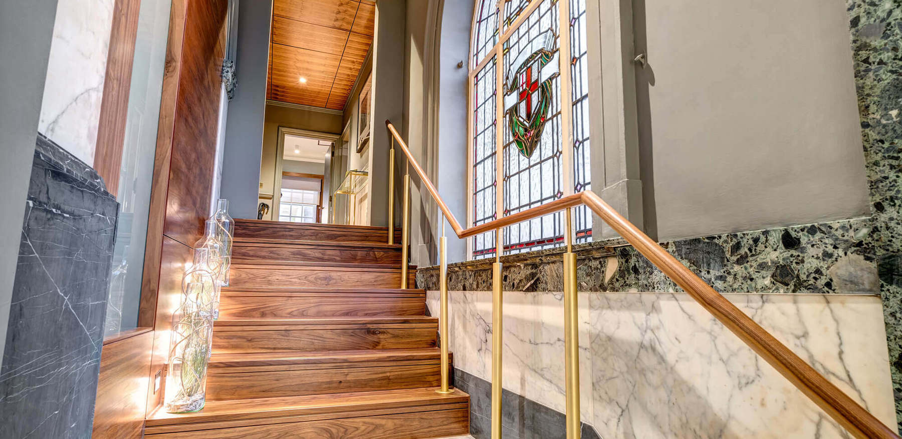 Grand Suite hallway with stairs and stained glass window at Apex Temple Court Hotel