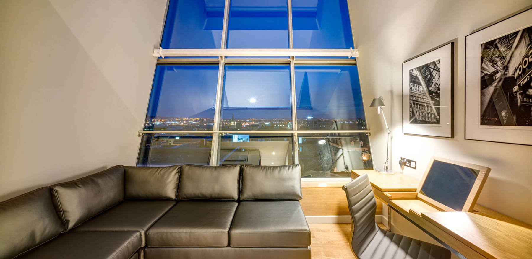 Duplex Suite lounge area with sofa and TV and city view