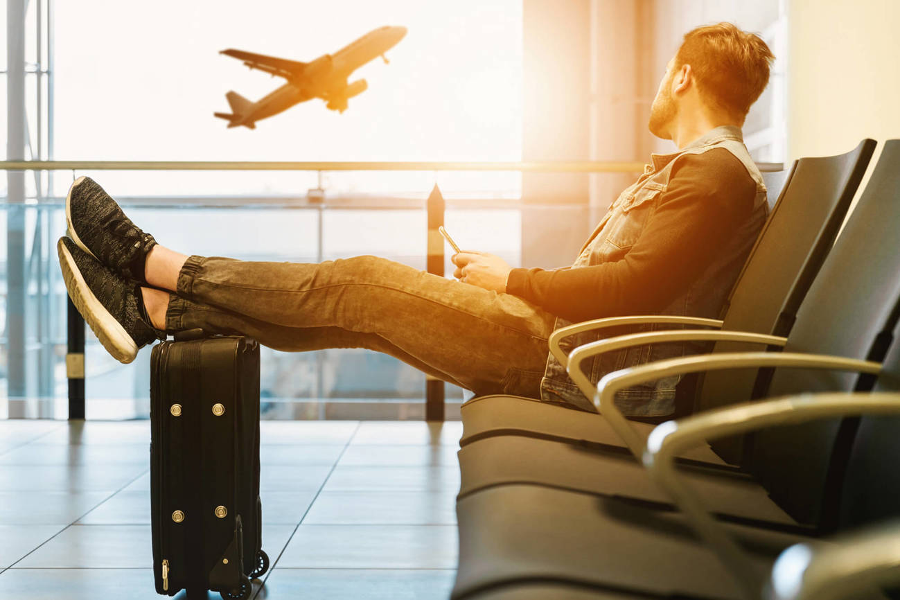 Man in airport watching plane take off