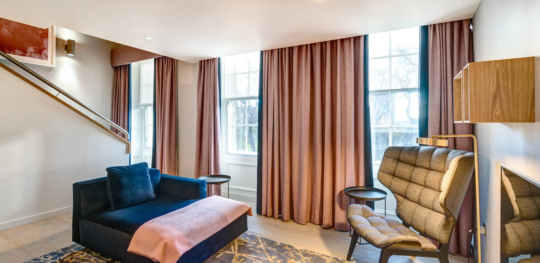 Duplex Suite living area with blue velvet sofa and upstairs