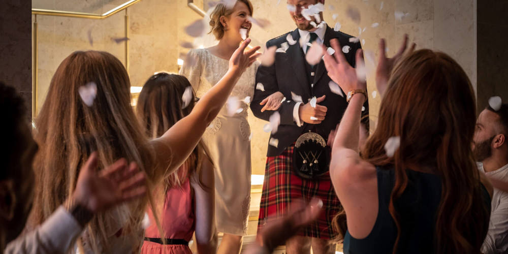 Bride and groom with crowd throwing confetti
