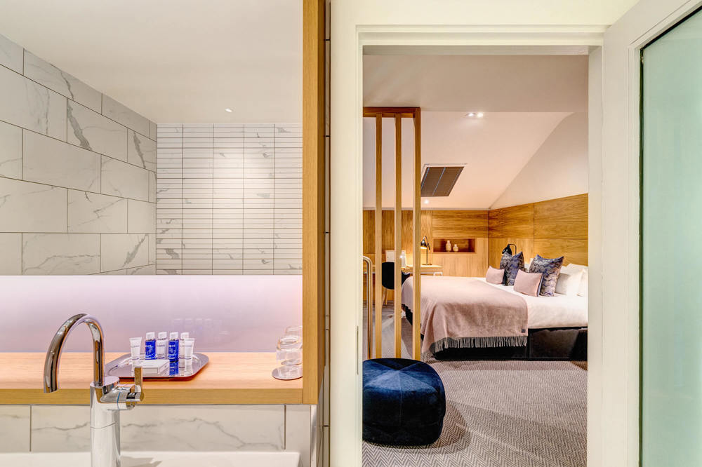 Bathroom and upstairs bedroom area in Duplex Suite at Apex Waterloo Place Hotel