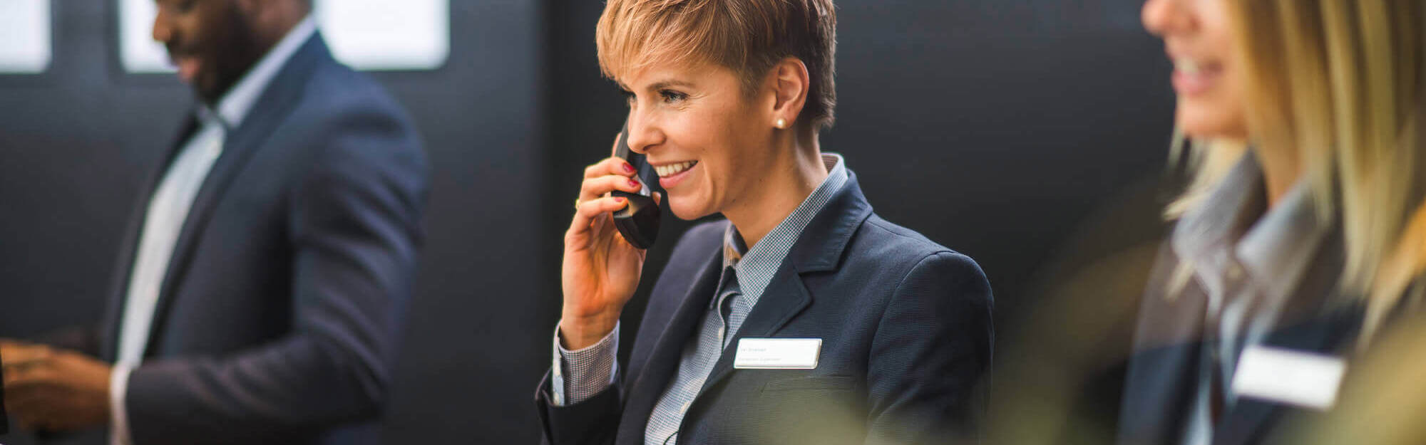 Three receptionists with female employee in the middle on the phone