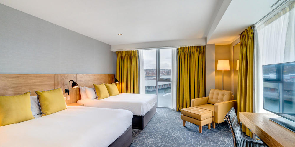 Family Room with City Quay views and two beds, desk and armchair