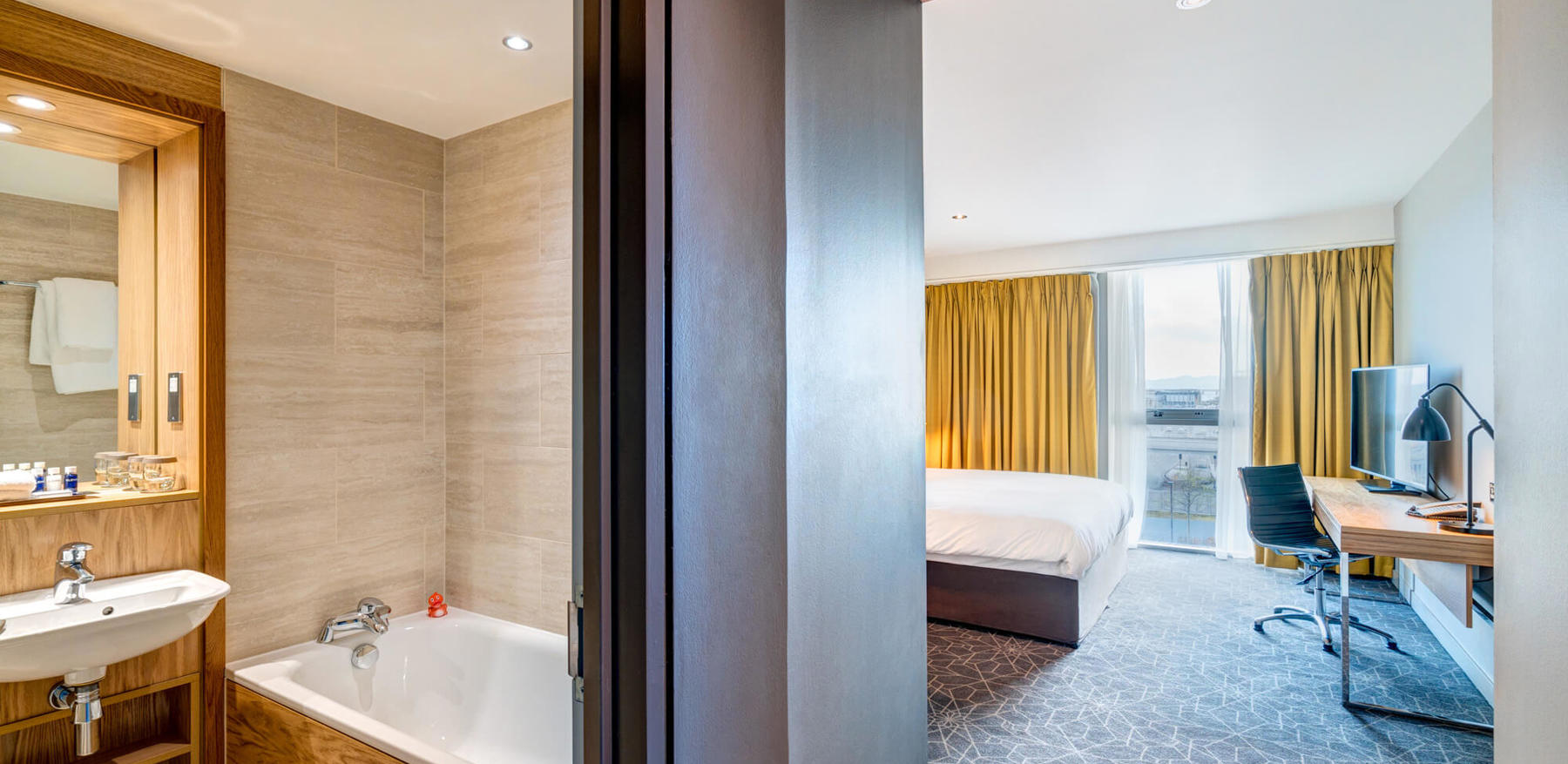 Bathroom with tub and bedroom with king-size bed