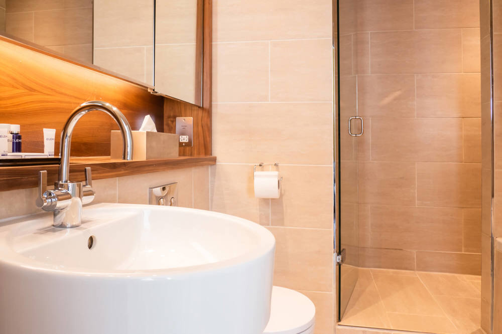 Family Room bathroom sink and walk-in shower at Apex Waterloo Place Hotel