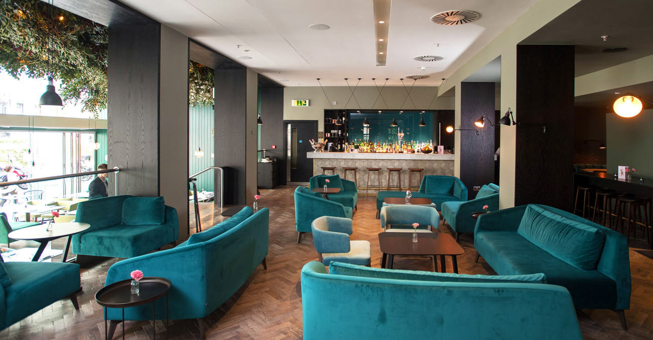 The bar in The Lampery with velvet sofas and parquet flooring